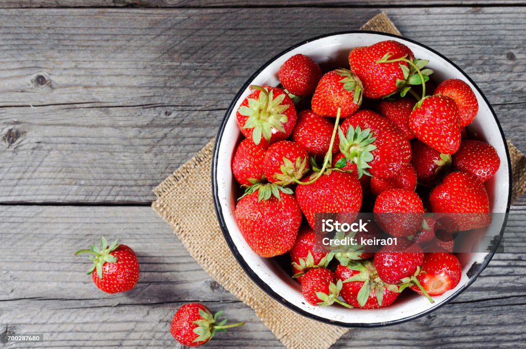 Red berry strawberry in metal mug on rustic wooden background. Directly above. Top view. Red berry strawberry in metal mug on rustic wooden background. Background from freshly harvested strawberries. Directly above. Top view. Horizontal. Bowl Stock Photo