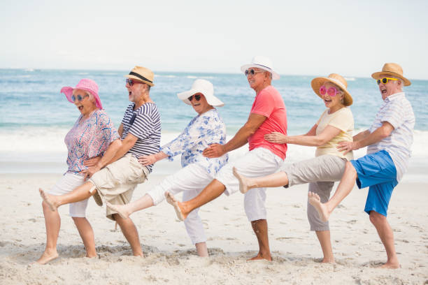 amici anziani che ballano sulla spiaggia - beach women joy sand foto e immagini stock