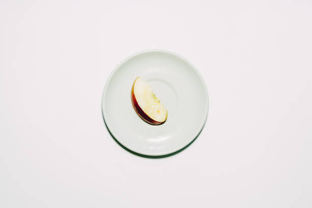 istock Apple slice on white and orange plate over white background 700313502