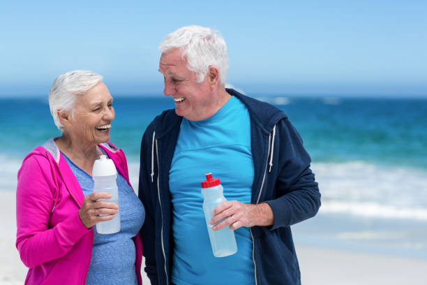 istock Mature couple holding water bottles together 700318738