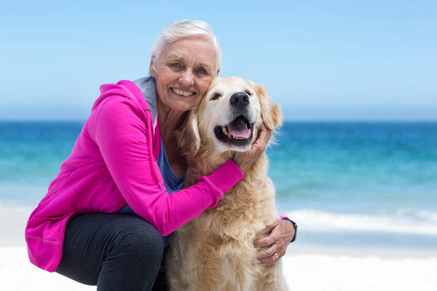 istock Cute mature woman petting her dog 700319018