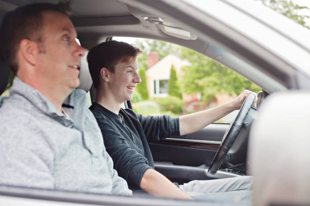 Teenager Learning to Drive A teenage boy is excited learning to drive while his dad is terrified. teenager boy driving stock pictures, royalty-free photos & images