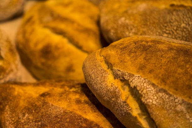 хлебные буханки. буханка хлеба. свежий хлеб в пекарне. хлебные буханки фон - brown bread bread wheat bakery стоковые фото и изобр�ажения