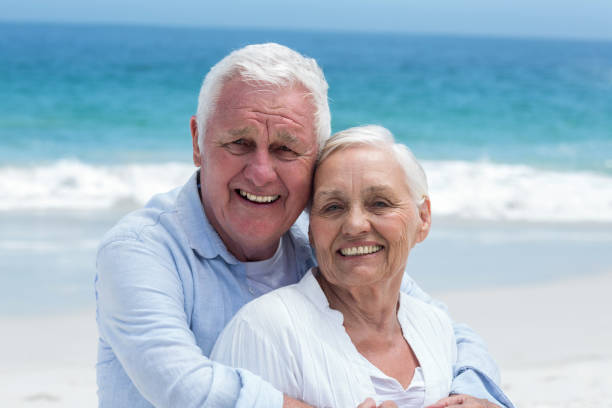 istock Senior couple embracing with arms around 700338750