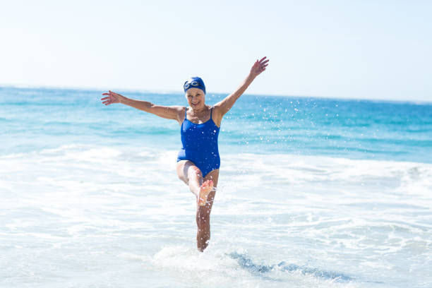 istock Pretty mature woman playing on the beach 700362482