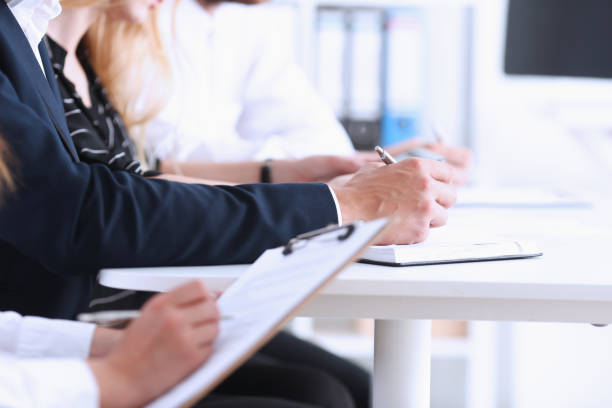 istock A group of people at a seminar make notes in a notebook with a pen 700363928