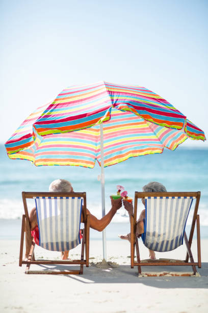 istock Cute mature couple lying on deckchairs 700365554