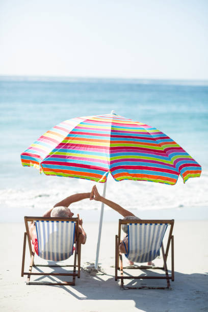 istock Cute mature couple doing high five on deckchairs 700366674