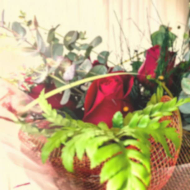 Blured view of gift bouquet of red roses in a wicker basket