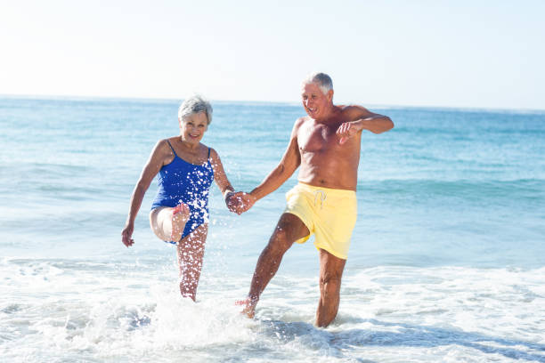 istock Senior couple playing with waves 700378500