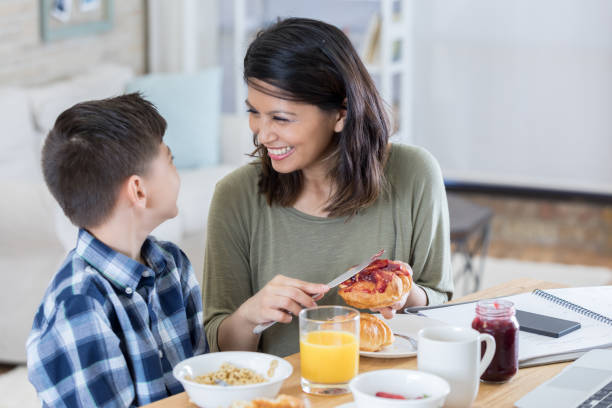 istock Beautiful mid adult Asian mom has breakfast with young son 700379042