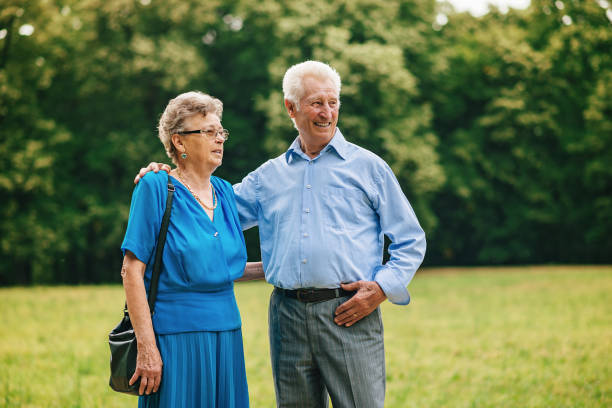 istock Senior couple walking in park 700382620