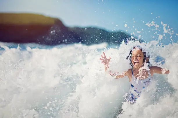 Photo of Girl is jumping and playing in the ocean in the big waves