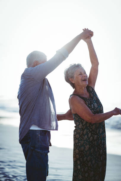 istock Senior couple dancing at the beach 700415324