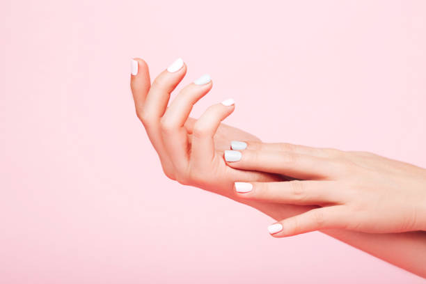 Tender hands with perfect manicure Tender hands with perfect blue and pink manicure on trendy pastel pink background. Place for text. good condition stock pictures, royalty-free photos & images