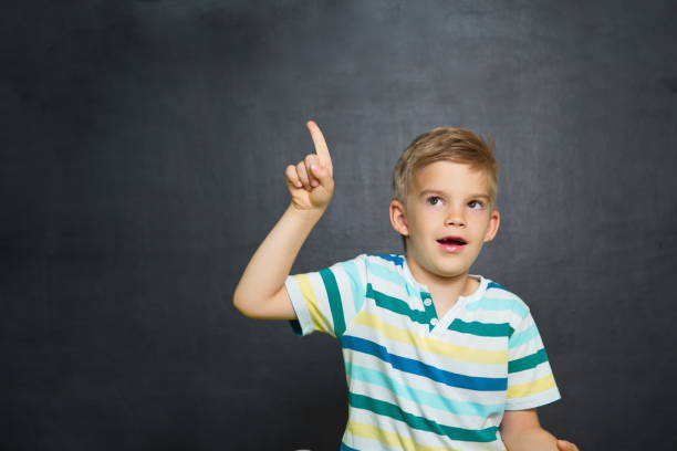 istock School boy is standing with blackboard behind him 700454954
