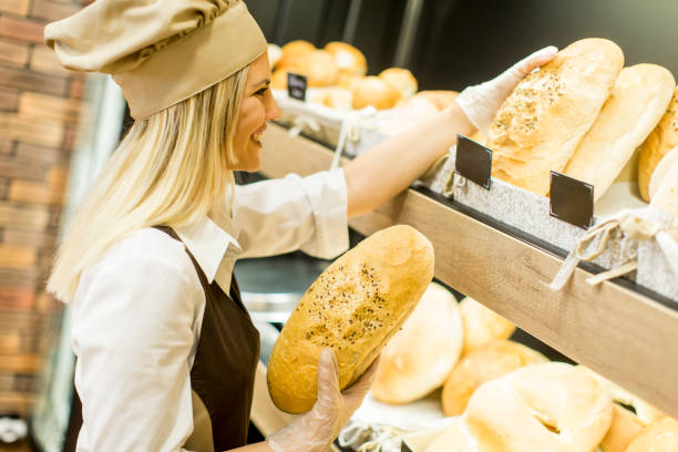 istock Pretty young woman selling bread in the bakery 700470236