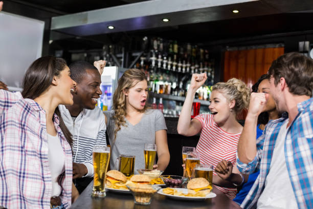 istock Happy friends having a drink and watching sport 700474304