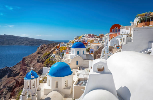 istock Santorini blue dome churches on the steep cliff, Greece 700474312