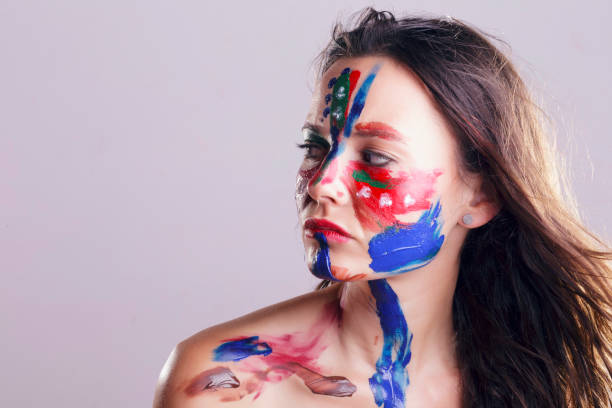 istock Girl with her face painted with her own hands. 700492218