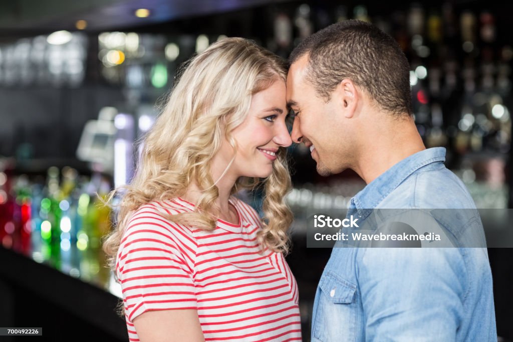 Smiling couple looking at each other Smiling couple looking at each other in bar 20-24 Years Stock Photo