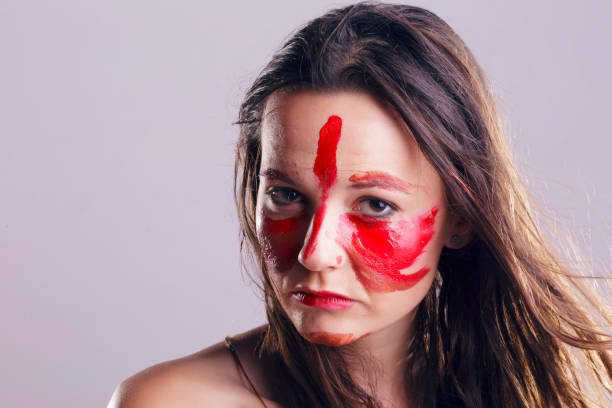 istock Girl with her face painted with her own hands. 700492386