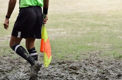 Soccer assistant referee is running along side line