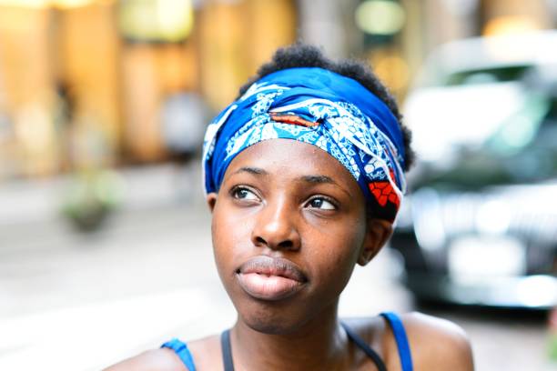Closeup of a young black woman in traditional African dress, looking away.