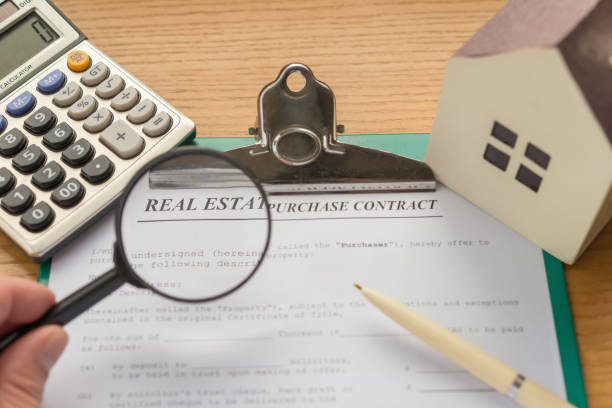 istock real estate purchase contact with an architectural model and a calculator with some part highlighted 700554020