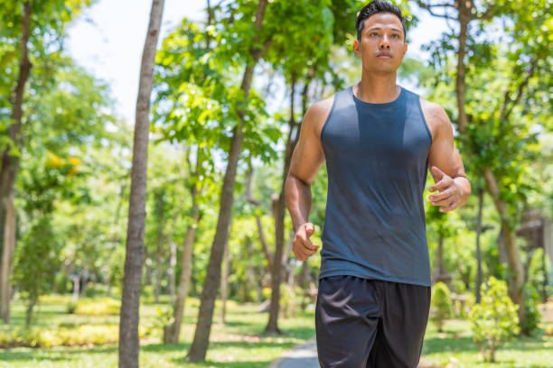 istock Fit Muscular Man Jogging in a Park 700558596
