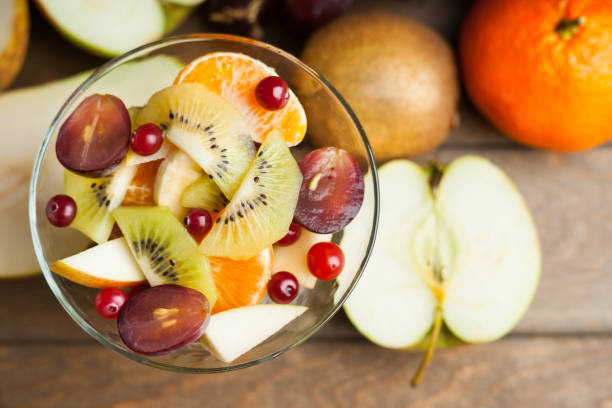 istock Fresh fruit salad and fruits on wooden table 700572992