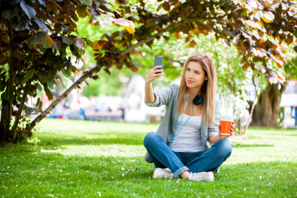 istock Woman using smartphone at the park 700581196