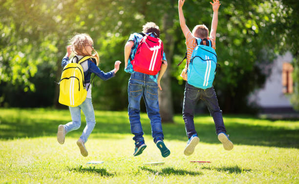 istock Children with rucksacks standing in the park near school 700581320