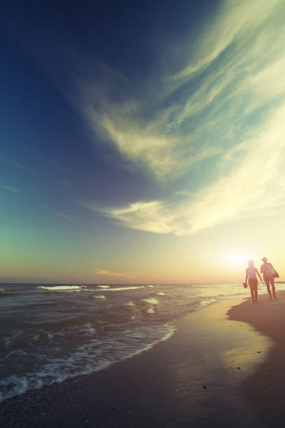 istock Two young girls walking along the coast at sunset 700584808