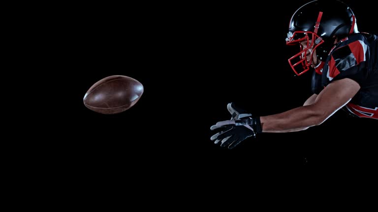 SLO MO LD American football player jumping into the air and catching the ball while airborne