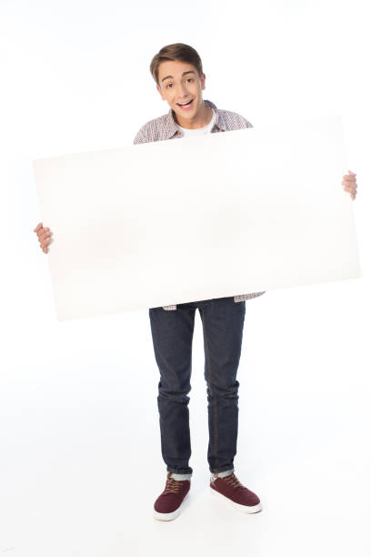 istock smiling teenage boy holding blank banner isolated on white 700599982