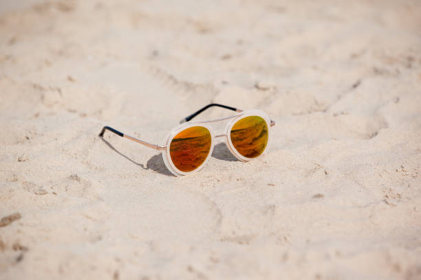 istock Sunglasses on sandy beach in summer 700600364