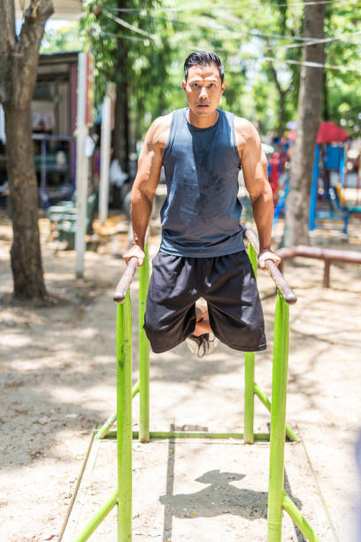 istock Asian Man Lifting Weights at a Makeshift Outdoor Gym 700602470