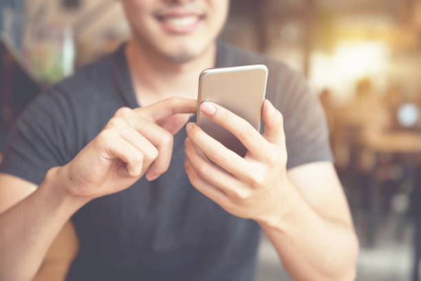 istock Happy man using smartphone at modern coffee shop. 700603120