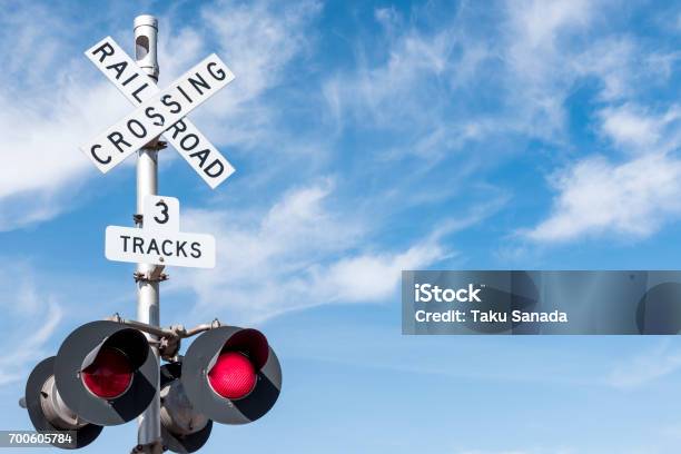 Railroad Crossing With Wispy Cloud In Blue Sky Behind Stock Photo - Download Image Now