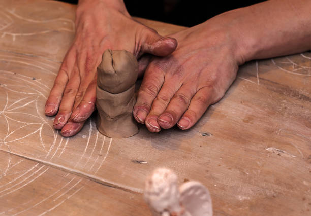 istock hands working and finishing sculpture with clay on wooden table in workshop 700608918