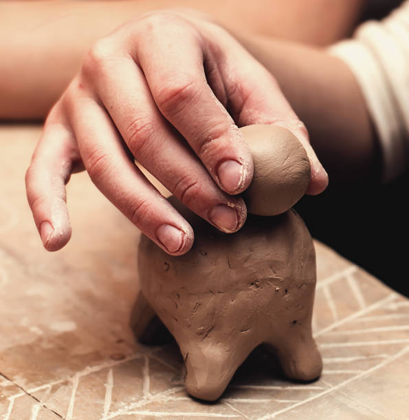 istock hands working and finishing sculpture with clay on wooden table in workshop 700609086