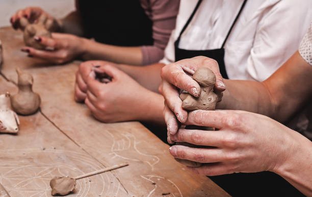 istock hands working and finishing sculpture with clay on wooden table in workshop 700609094