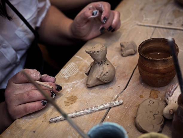 istock hands working and finishing sculpture with clay on wooden table in workshop 700609160