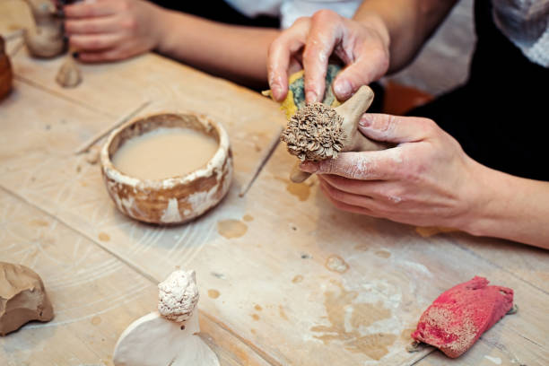 istock hands working and finishing sculpture with clay on wooden table in workshop 700609300