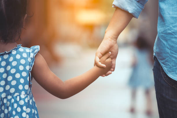 Mother and daughter holding hand together in vintage color tone stock photo