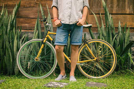 Young attractive man enjoying outdoors with old bicycle.