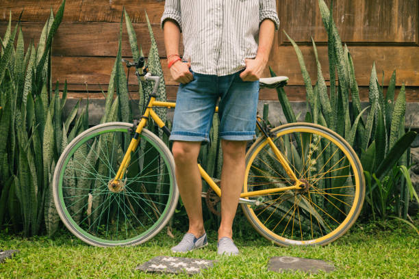 atraente jovem desfrutar ao ar livre com bicicleta velha. - short cycle - fotografias e filmes do acervo