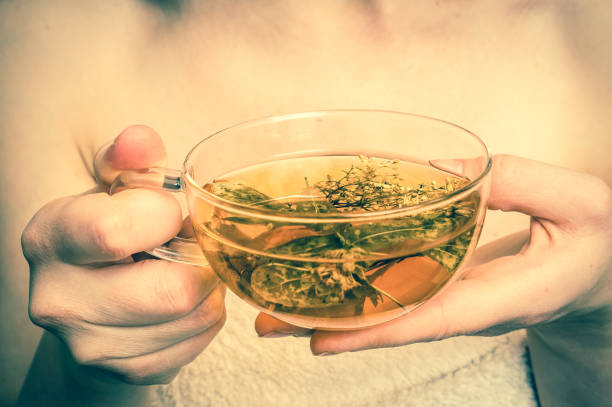 istock Beautiful woman with hot tea cup in her hands 700630310