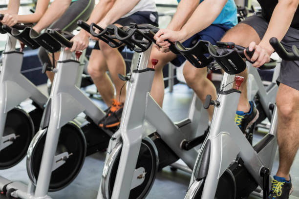 istock Fit group of people using exercise bike together 700633704